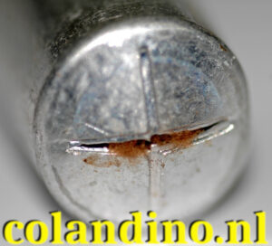 Close-up van een kapotte elektrolytische condensatoropening en opgedroogde elektrolytresten